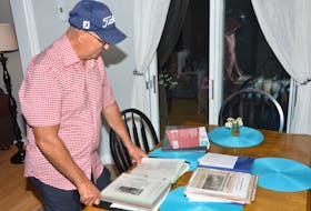 Ivan Gallant, race director of the Harvest Festival 25K Road Race, checks out the extensive history of the event. The 47th running of the race will take place on Aug. 21.