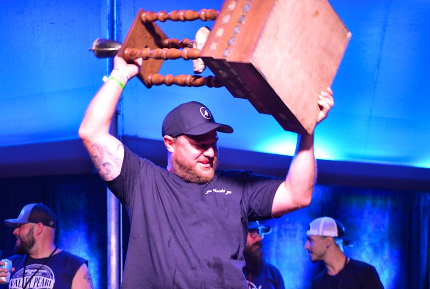 Eamon Clark hoists the Shuck Cup after being named the winner of the 2021 Canadian Oyster Shucking Competition. Clark is now a 10-time Canadian champion.
