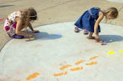  Nine-year-old Elizabeth Prokop, left, and her four-year-old sister Evelyn use some chalk to make some footprints. Photo taken on Saturday, Aug. 14, 2021 in Regina. TROY FLEECE / Regina Leader-Post