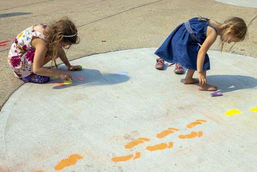  Nine-year-old Elizabeth Prokop, left, and her four-year-old sister Evelyn use some chalk to make some footprints. Photo taken on Saturday, Aug. 14, 2021 in Regina. TROY FLEECE / Regina Leader-Post