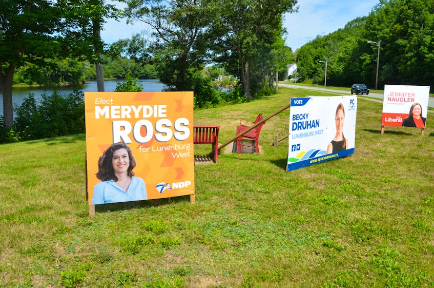 Lunenburg West election campaign signs stake out party territory on the grass next to the Veterans Memorial Bridge in Bridgewater. - Francis Campbell