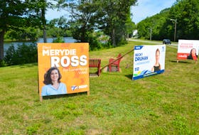 Lunenburg West election campaign signs stake out party territory on the grass next to the Veterans Memorial Bridge in Bridgewater.