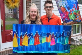 Jax Gaudet and his mother, Lana McMackin, hold up a painting by Adam Young of Young Studios that will be auctioned online for Jax's Make-A-Wish fundraiser. Before this, he has an even bigger fundraiser - VIP weekend passes for County Rocks the Hub and Rock the Hub festivals.