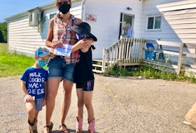 Alison Lewis, centre, with her children three-year-old Colten and seven-year-old Nora, stand outside of the voting station in Howie Centre at the Royal Canadian Legion branch 151.