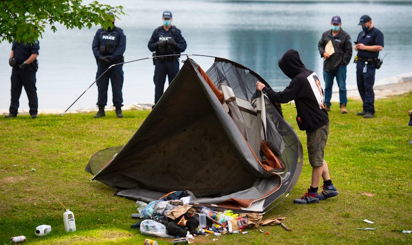A homeless man is forced to dismantle his tent in Horseshoe Island Park in Halifax during a police sweep of encampments in public spaces. - Ryan Taplin