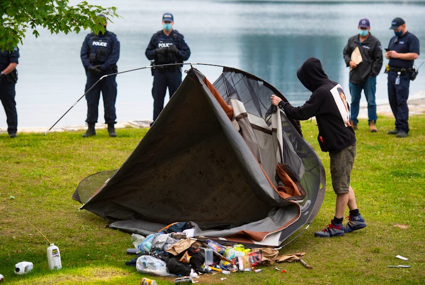 A homeless man is forced to dismantle his tent in Horshoe Island Park in Halifax during a police sweep of encampments in public spaces.