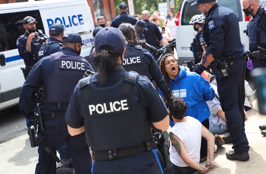 A woman shouts as she's arrested by Halifax Regional Police during a protest against the removal of temporary housing shelters in downtown Halifax on Wednesday, Aug. 18, 2021. - Tim  Krochak