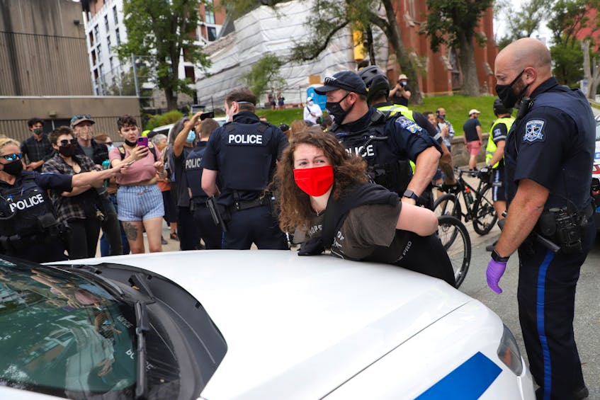 A woman arrested as protesters clashed with police in Halifax on Wednesday, Aug. 18, 2021, over a crackdown on temporary housing sites. - Tim  Krochak