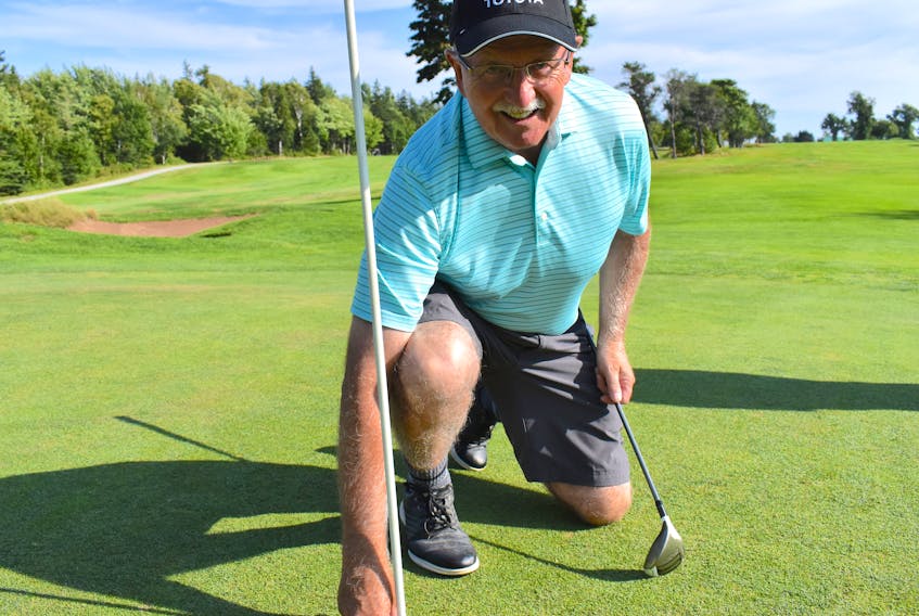 Eddie Moules of Whitney Pier kneels down to get a ball out of No. 10 hole at Lingan Golf and Country Club on Tuesday. The 70-year-old hit a rare albatross on the hole earlier this month, becoming the second Cape Breton golfer to record the occurrence this summer. JEREMY FRASER/CAPE BRETON POST.