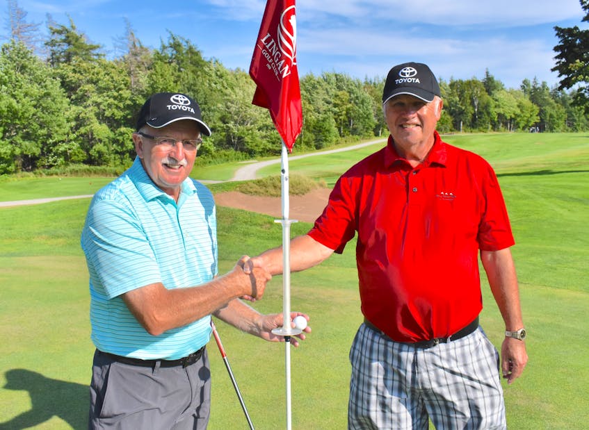 Eddie Moules, left, shakes the hand of playing partner and friend Richie Paruch near the No. 10 hole at Lingan Golf and Country Club on Tuesday. Moules recorded a rare albatross on the hole earlier this month. JEREMY FRASER/CAPE BRETON POST. - Jeremy Fraser