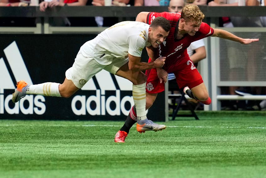 Atlanta United defender Brooks Lennon (left) battles with Toronto FC's Jacob Shaffelburg during the first half at Mercedes-Benz Stadium on Wednesday, Aug. 18, 2021.