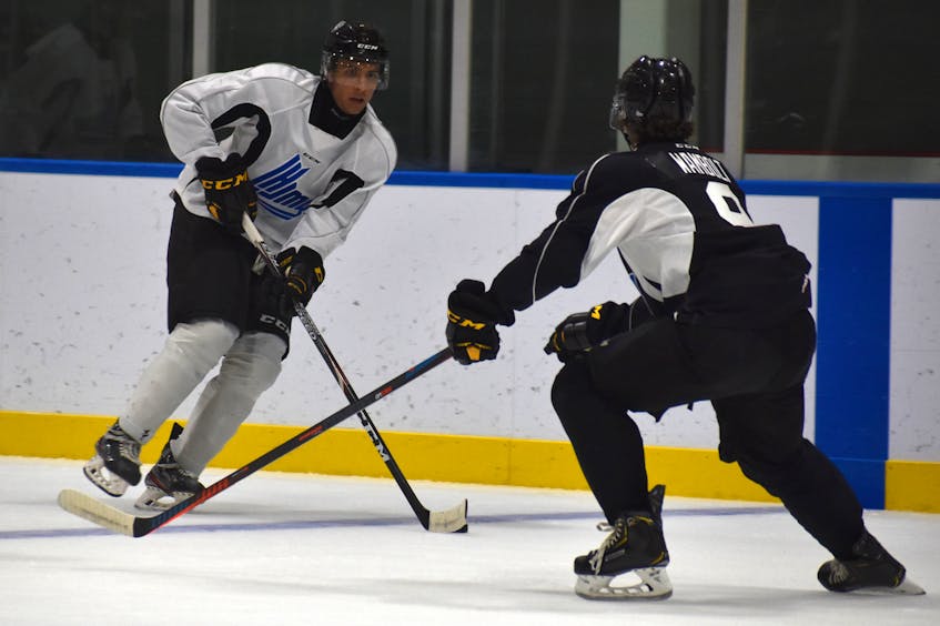 Emile Perron, left, carries the puck into the offensive zone as he’s watched by Brady Wambolt during Cape Breton Eagles rookie camp black and white intrasquad game at Miners Forum in Glace Bay, Thursday. JEREMY FRASER/CAPE BRETON POST. - Jeremy  Fraser