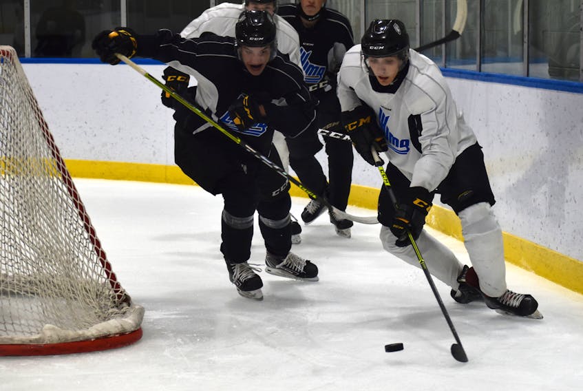 Sydney’s Trey Sturge, right, holds the puck behind the net as he’s chased by Luke Patterson during Cape Breton Eagles rookie camp black and white intrasquad game at Miners Forum in Glace Bay, Thursday. JEREMY FRASER/CAPE BRETON POST.