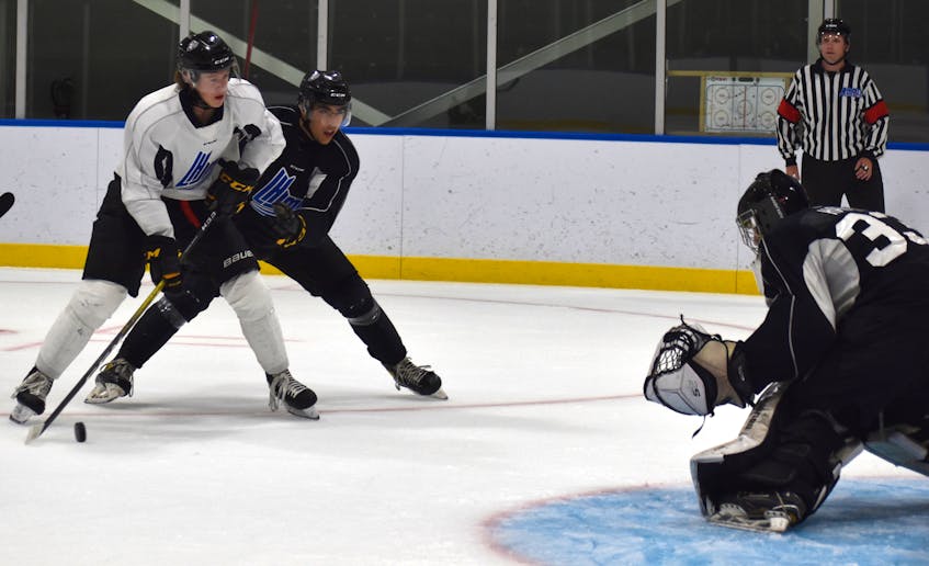 Liam Travis, left, works his way to the net as Matheas Elles pressures and goaltender Kenzie MacPhail of Inverness watches during Cape Breton Eagles rookie camp black and white intrasquad game at Miners Forum in Glace Bay, Thursday. JEREMY FRASER/CAPE BRETON POST. - Jeremy  Fraser