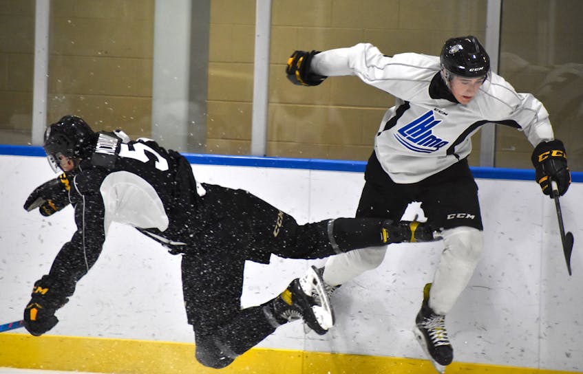 Michael McQuaid, left, gets a piece of the body as Sydney’s Preston Pattengale tries to sneak past the check during Cape Breton Eagles rookie camp black and white intrasquad game at Miners Forum in Glace Bay, Thursday. JEREMY FRASER/CAPE BRETON POST. - Jeremy  Fraser