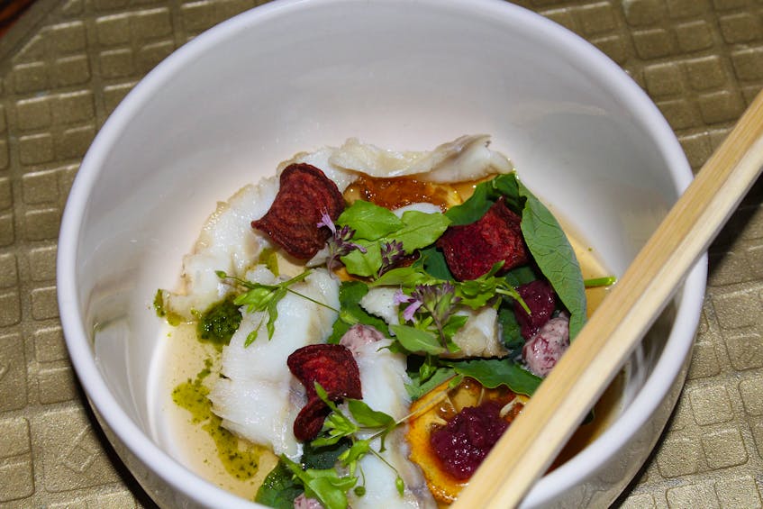 The Aurora Club's dish of pickled haddock comes with nasturtium wasabi, burnt cabbage and shallot butter, rhubarb gel, candy lemon, berries and beet chips, and a dashi broth. — Andrew Waterman/The Telegram