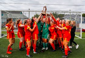 Members of the Holy Cross Kirby Group Crusaders hoist the championship trophy after winning their sixth straight Breen's Jubilee Trophy women's soccer title Sunday in Conception Bay South. — Trevor Wragg photo/via Twitter