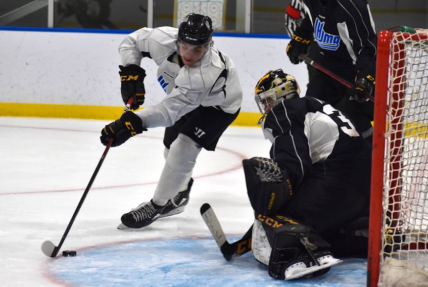 Team White forward Kiefer Lyons prepares to make a move in-tight at the top of the crease as Team Black goaltender Nicolas Ruccia watches the puck closely during Cape Breton Eagles black and white intrasquad game at Miners Forum in Glace Bay on Monday. Team Black won the game 7-2.
