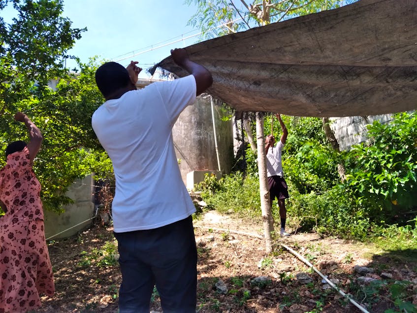 A family sets up a tarp for temporary shelter in quake-hit southwest Haiti. - contributed by Chalice Canada 