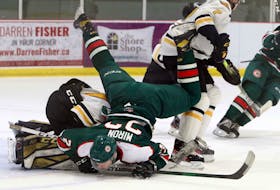 Mooseheads' Landon Miron falls over Cape Breton goaltender Thomas Pigeon on a scoring attempt late in the first period.