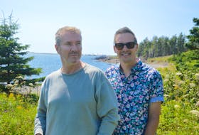 Internationally celebrated interior designers Justin Ryan, left, and Colin McAllister stand on the grounds of the Point of View Suites in Louisbourg. The couple plans to remodel the scenic seaside retreat and relaunch it as North Star. Chris Connors/Cape Breton Post