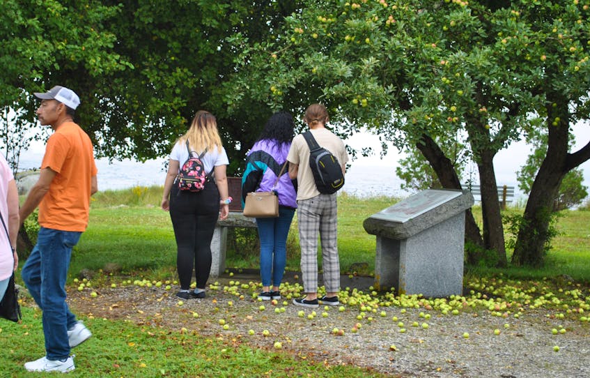 People stop to look at the national historic site monument commemorating the 1783 Black Loyalist landing in Birchtown during the service of remembrance and rose laying ceremony in recognition the United Nations International Day for the Remembrance of the Slave Trade and its Abolition on Aug. 23. KATHY JOHNSON - Kathy Johnson