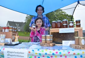 Lisa Stinson of Maggies Farm in Earltown, shown with her daughter and business namesake, Maggie, during a recent farmer's market at Sullivan's Family Farm in Nuttby. Stinson markets pure wildflower honey concoctions and a variety of all-natural beeswax products.