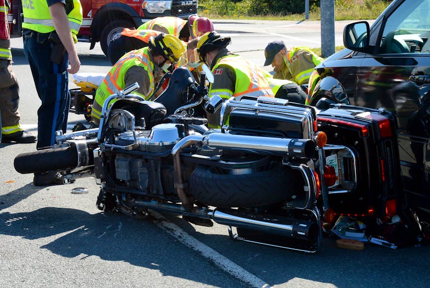 First responders tend to the male driver of a motorcycle who collided with two vehicles Thursday afternoon on Southlands Boulevard. Keith Gosse/The Telegram