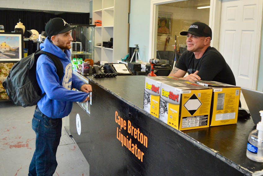 Customer Kyle MacInnis, left, talks business with Cape Breton Liquidator owner Mike Ranni at the upper George Street, Sydney establishment. DAVID JALA • CAPE BRETON POST