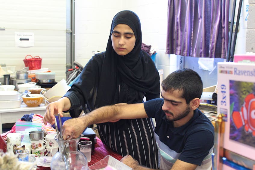 Hanan Al Rahal, left, and her brother Zeid Al Rahal sort utensils at Gifts From The Heart on Aug. 26, 2021 as the organization prepares for its monthly sale.  - Ryan Ross
