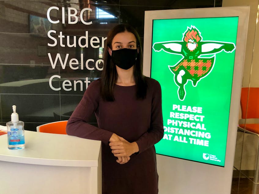 Cape Breton University Students' Union President Madlyn O'Brien stands near an electronic sign promoting social distancing in the halls. NICOLE SULLIVAN/CAPE BRETON POST