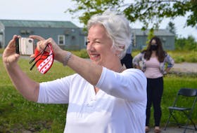 Cape Breton native and renowned Canadian businesswoman Annette Verschuren not only makes news – she also likes to be there when it happens. Verschuren, who is being inducted into the Cape Breton Business and Philanthropy Hall of Fame for a second time, is shown above taking pictures at a recent solar energy project announcement at the site of the former Canadian Forces Base Sydney. DAVID JALA/CAPE BRETON POST