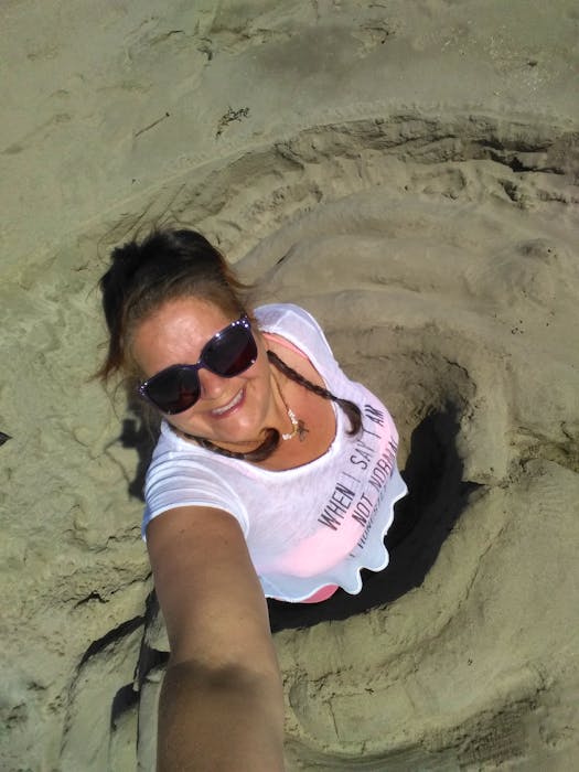 Liza Robicheau-Blooi inside one of her sand sculptures in progress at Port Maitland Beach. - Contributed