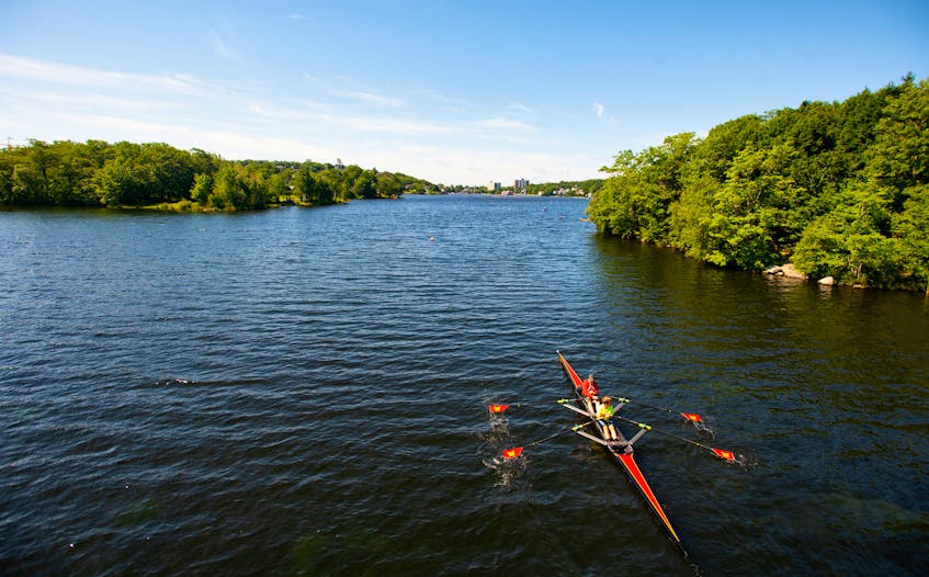 A pair of rowers pass under the pedestrian bridge over Lake Banook on a sunny Tuesday morning. - Ryan Taplin