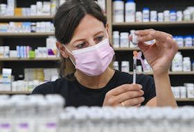 Barbara Violo, pharmacist and owner of The Junction Chemist Pharmacy, draws up a dose of the Pfizer-BioNTech COVID-19 vaccine, in Toronto, Friday, June 18, 2021.