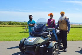 Savneet Singh, left, stands nearby as daughter Ajooni Kaur tries out Legendary Sikh Rider Dalel Singh Brar’s motorcycle in North Carleton on Aug. 3.  Alison Jenkins • Special to The Guardian