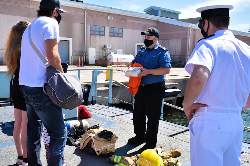 An engineer onboard HMCS Summerside, trained for damage control in fires and floods, explained some of the gear used to fight shipboard fires to a small group touring the ship on Saturday, Aug. 28. - Desiree Anstey