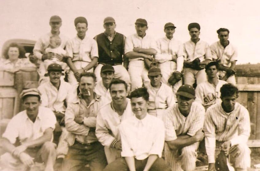 Members of the 1950 Petit-de-Grat Red Caps baseball team from Richmond County. From left, front row, Colin MacLean (umpire), Cletus Boudreau, Fulbert Boudreau, Laurier Boudreau (bat boy), Edwin Power and Rudolph Boudreau; middle row, Peter Boudreau, Adolph Boudreau, Herman Samson, Joachim Boudreau; back row, Lorraine Sampson (fan), Louis Samson (holding baby Yvette), Jocelyn Landry, George Jollymore, Vincent Boudreau, Henry Fortune, Roy Boudreau and Clifford DeCoste. CONTRIBUTED