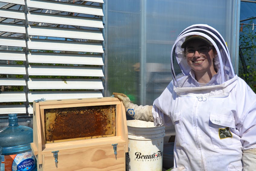 Madison Grace from New Waterford is shown with one of the beehives. ARDELLE REYNOLDS/CAPE BRETON POST