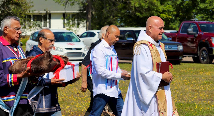 Mi'kmaq keptins and Father Gerard Chaisson deliver remains of five Prince Edward Island Mi'kmaq to a cemetery outside St. Bonaventure's Parish on Aug. 29. The remains had been taken to Memorial University in 1959. - Logan MacLean