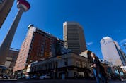 A masked pedestrian crosses the Centre Street in downtown Calgary on Friday, April 16, 2021. 