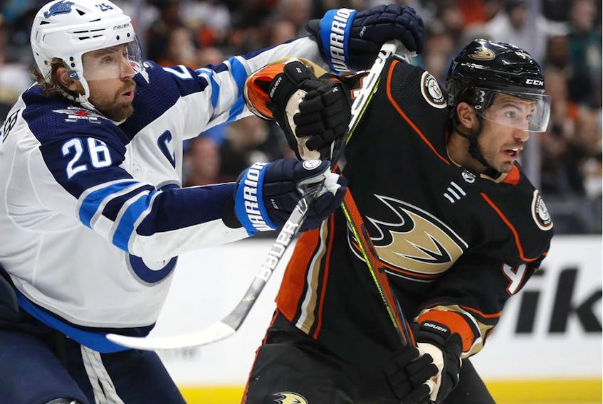 Michael Del Zotto, then a member of the Anaheim Ducks, battles Winnipeg's Blake Wheeler in October 2019.