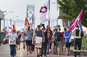Members of the Customs and Immigration Union and their supporters participate in a rally near the Ambassador Bridge in Windsor on Wednesday, August 4, 2021.