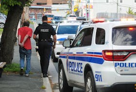 RNC officers are shown with an individual detained at the scene of an incident on Lemerchant Road in St. John's Saturday afternoon. The man had been searched and handcuffed, but had the handcuffs removed before being placed in the rear of a patrol car and taken from the scene. — Joe Gibbons/The Telegram
