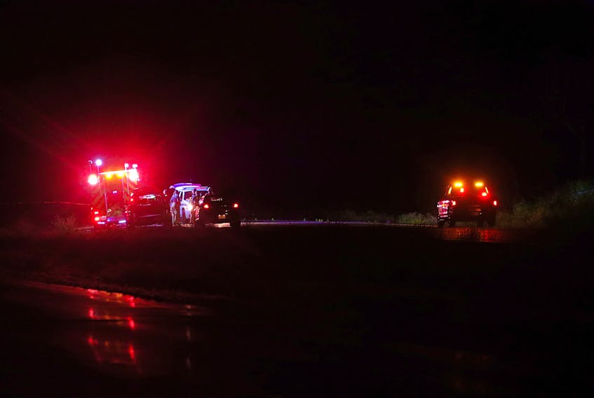 Police and firefighters talk near the scene of a fatal crash on Highway 101 near Mount Uniacke overnight Sunday. Two people died in the crash.