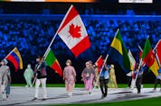 Canada's Damian Warner carries his national flag during the closing ceremony of the Tokyo 2020 Olympic Games, at the Olympic Stadium, in Tokyo, on August 8, 2021.