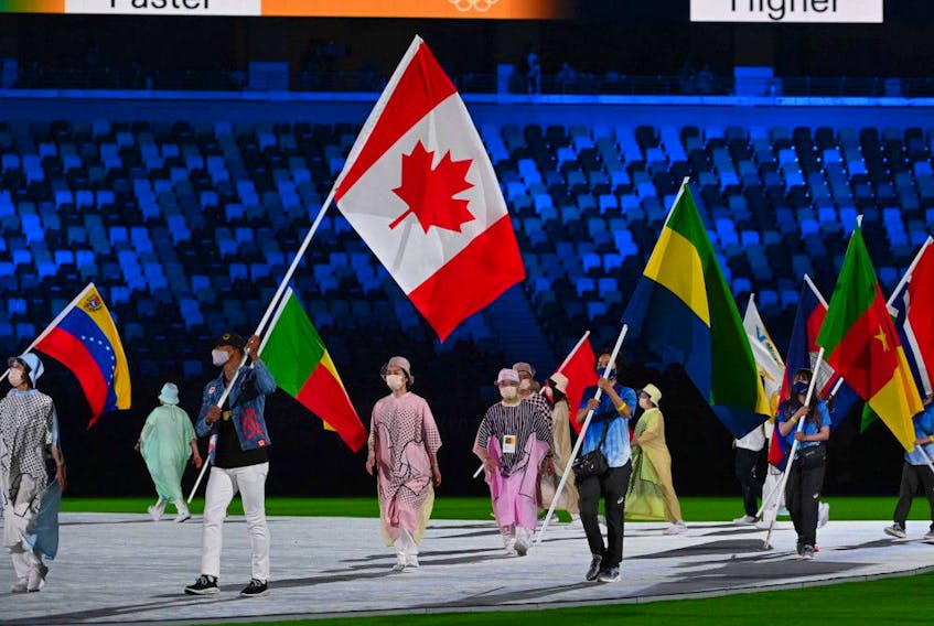 Canada's Damian Warner carries his national flag during the closing ceremony of the Tokyo 2020 Olympic Games, at the Olympic Stadium, in Tokyo, on August 8, 2021.
