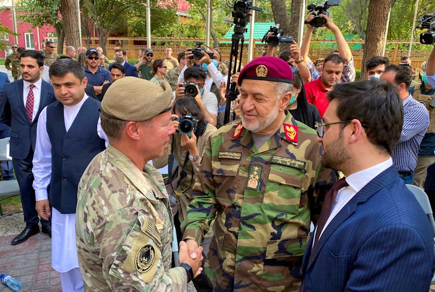 U.S. General Austin Miller, (left) shakes hand with Afghan Defense Minister Bismillah Khan Mohammadi on July 12, at a ceremony during the final phase of the withdrawal from the war in Afghanistan. Now Canada is scrambling to help Afghans who assisted its forces during the NATO-led effort. - REUTERS
