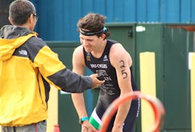 An exhausted Roughan Gaetz is congratulated by coach Mike On after winning the sprint draft legal triathlon during the sixth annual Tri-Lobster Triathlon in Summerside Sunday morning. Gaetz, 17, raced out of St. John's, N.L.
