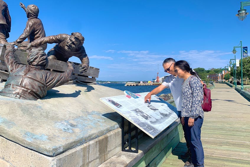 Siu and Jessica Yeung of Mississauga, Ont., view a monument dedicated to the merchant navy along the boardwalk at Sydney harbour Wednesday afternoon. The memorial recognizes the convoys of civilian-crewed ships carrying much-needed steel and coal which sailed from Cape Breton during the Second World War. Chris Connors • Cape Breton Post